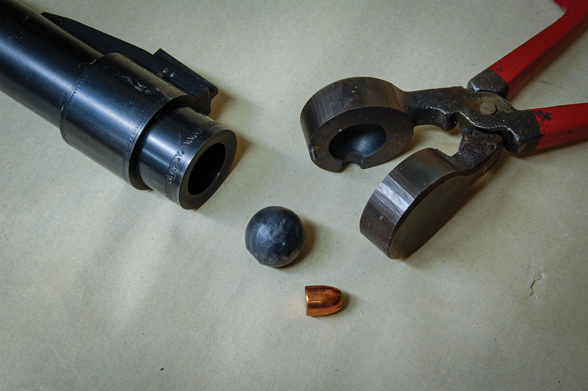The muzzle of a 12-bore ball gun with antique mould, round ball and 9 mm bullet for comparison.